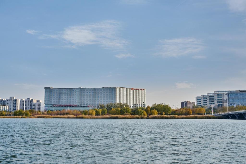 ein großer Wasserkörper mit Gebäuden im Hintergrund in der Unterkunft Crowne Plaza Tianjin Binhai, an IHG Hotel in Tianjin