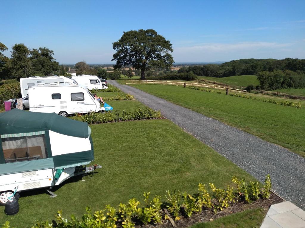 una caravana y una caravana estacionadas en un campo en Marbury Camp and Lodge en Whitchurch