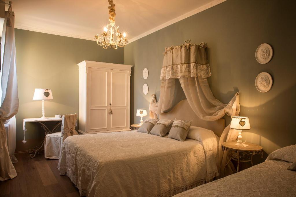 a bedroom with two beds and a chandelier at B&B Il Biancospino in Abbadia San Salvatore