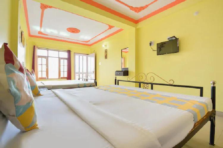 1 dormitorio con 1 cama grande y TV en la pared en Green Valley Home Stay, en Shimla