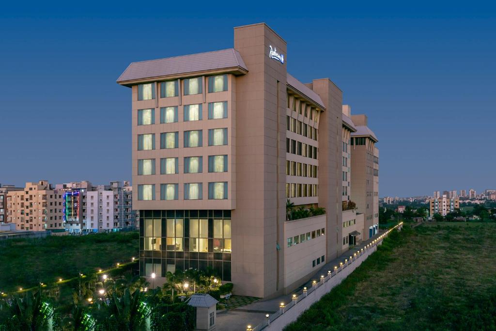 a large building with lights in front of it at Radisson Blu Pune Hinjawadi in Pune