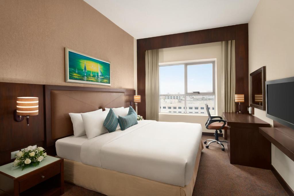 a hotel room with a large bed and a large window at Ramada by Wyndham Dubai Deira in Dubai