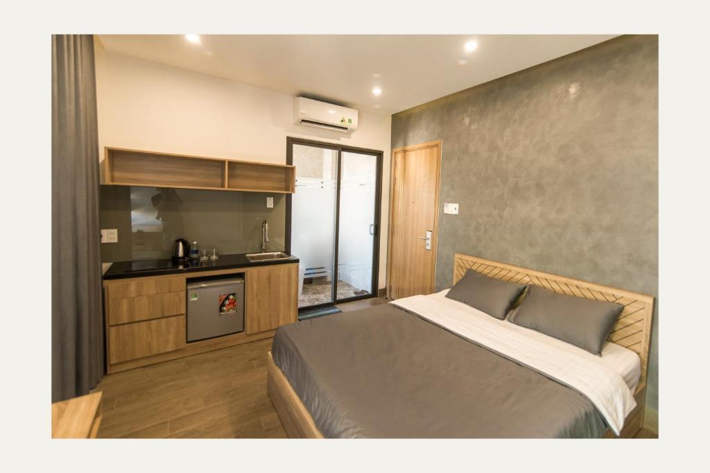 Il comprend une chambre avec un grand lit et une cuisine. dans l'établissement AHA Thang Bom Apartment Da Nang, à Đà Nẵng