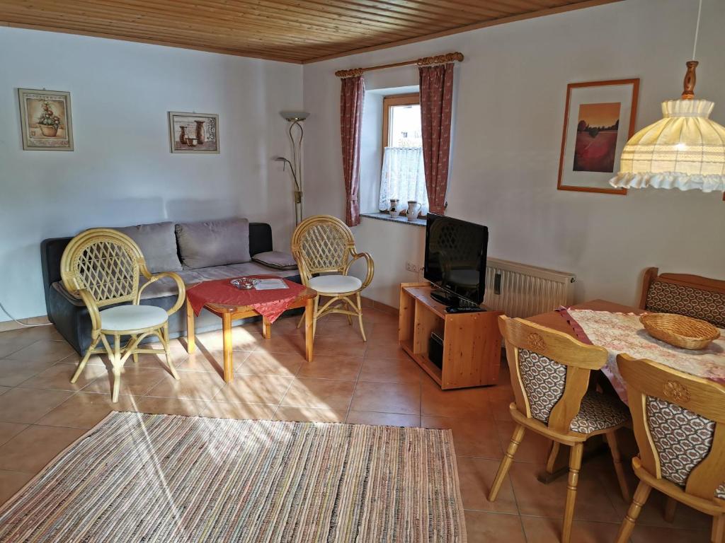 a living room with a couch and a table and chairs at Ferienhaus-Haidweg-Wohnung-1 in Haidmühle