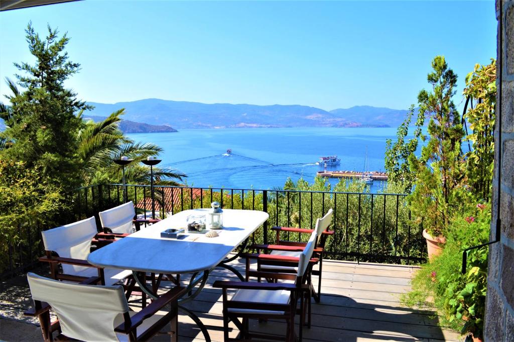 a table and chairs on a balcony with a view of the water at V. Molova, Molyvos, Lesvos in Mithymna