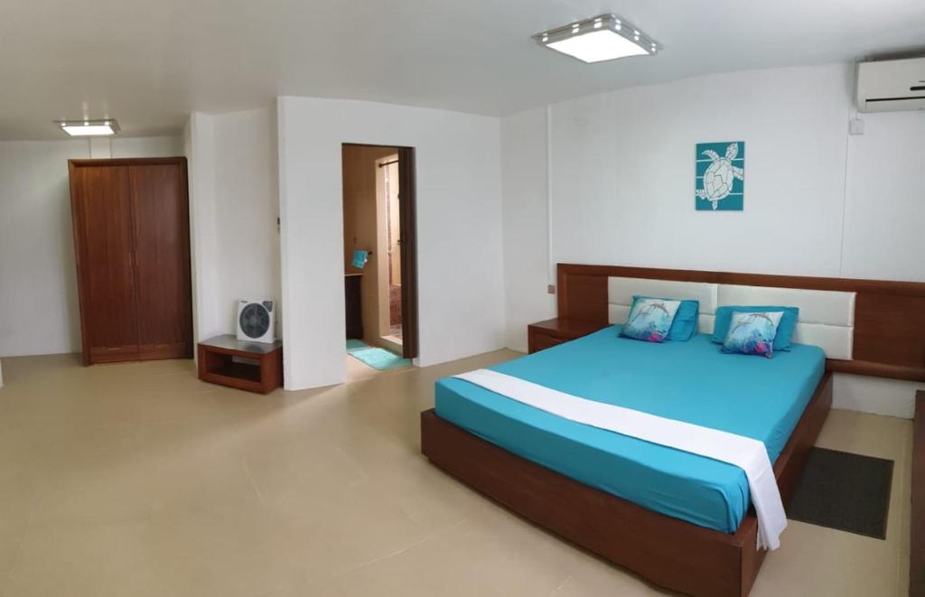1 dormitorio con 1 cama azul en una habitación en Admiralmahé en Mahébourg