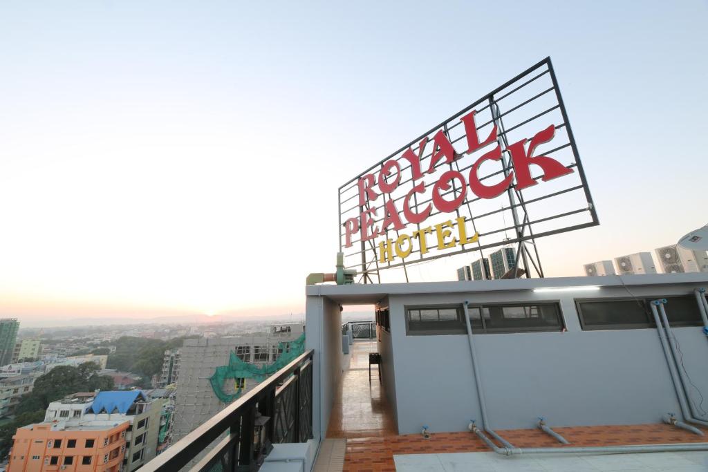 曼德勒的住宿－Royal Peacock Hotel，大楼顶部带有标志的阳台