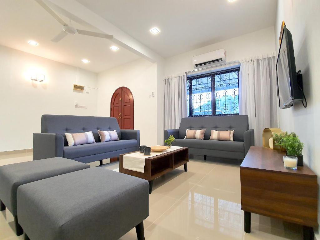 a living room with two blue couches and a table at Kuala Lumpur Jalan Ipoh Terrace House in Kuala Lumpur