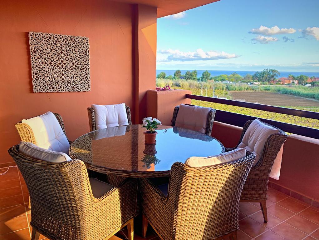 einen Tisch und Stühle auf einem Balkon mit Aussicht in der Unterkunft 2303-Huge 2 bedrooms apt with sea view in Manilva