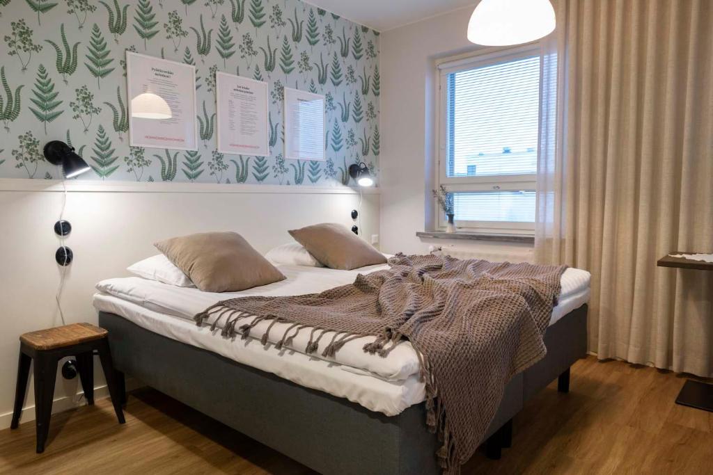 ein Schlafzimmer mit einem Bett mit einer Decke darauf in der Unterkunft Lietsu Boutique Aparthotel - Huoneistohotelli Lietsu in Joensuu