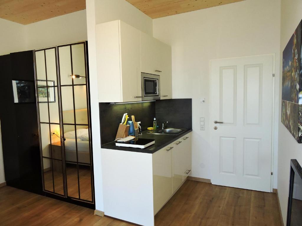 a kitchen with white cabinets and a black counter top at 213 Prag, Studio Apartment, 27m2, 1-2 Personen in Klagenfurt