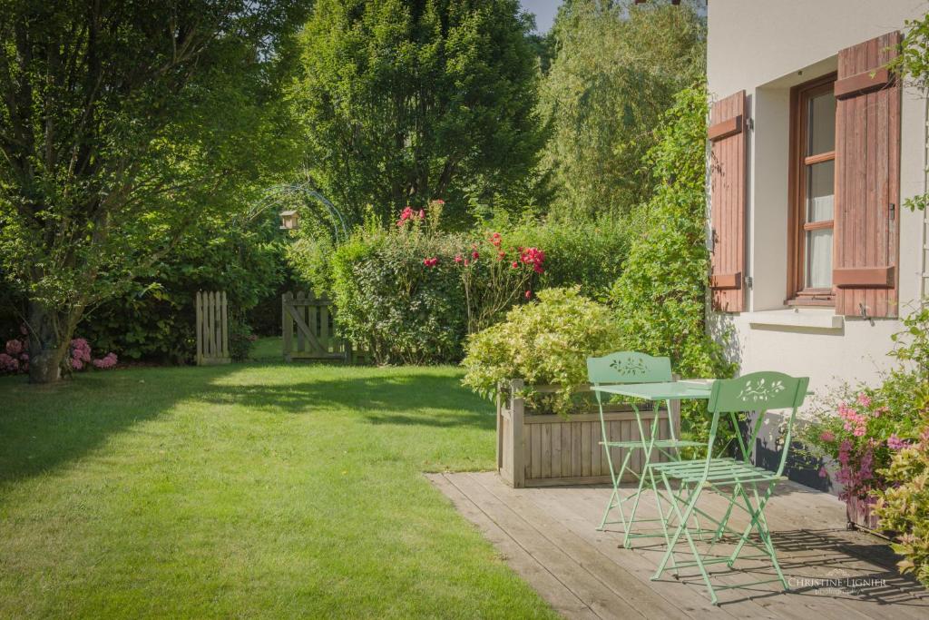 un patio avec deux chaises et une table dans une cour dans l'établissement Le Clos de l’Ermitage, à Saint-Josse