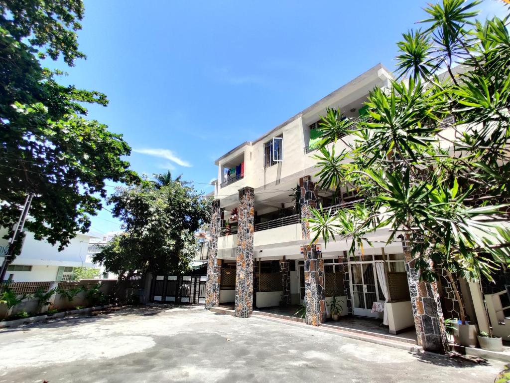 a building with palm trees in front of it at Pereybere Beach Apartments in Pereybere