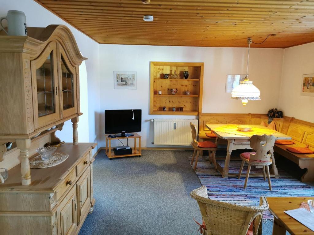 ein Esszimmer mit einem Tisch und einem TV in der Unterkunft Ferienhaus Haidweg, Wohnung 2 in Haidmühle