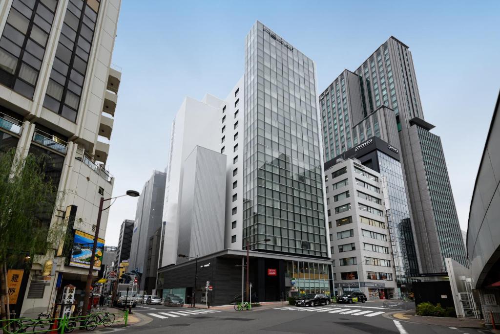 a group of tall buildings in a city at remm plus Ginza in Tokyo