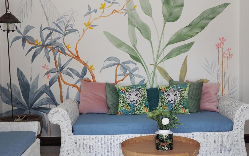 - un salon avec un canapé bleu et des oreillers colorés dans l'établissement Rayong Beach House, à Ban Bang Nok