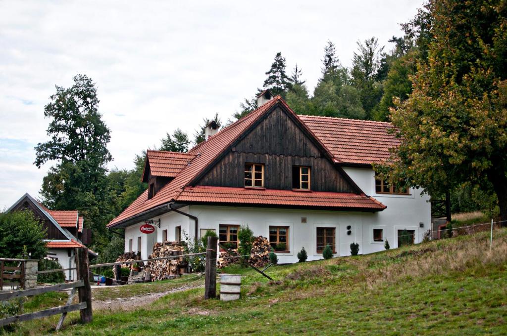 una casa blanca con techo rojo en una colina en Pension Jízdárna, en Morávka