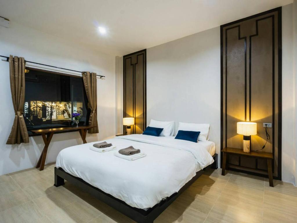 Ban Nong SrahにあるNararin Garden Houseの大きな白いベッドと窓のある寝室