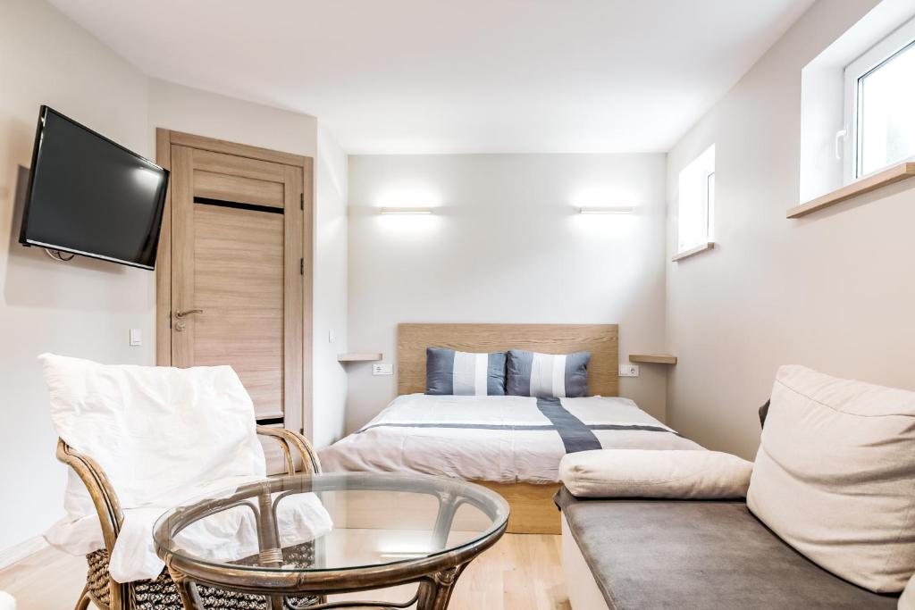 - une chambre avec un lit, un canapé et une table dans l'établissement Scandinavian Style Apartments, à Gargždai