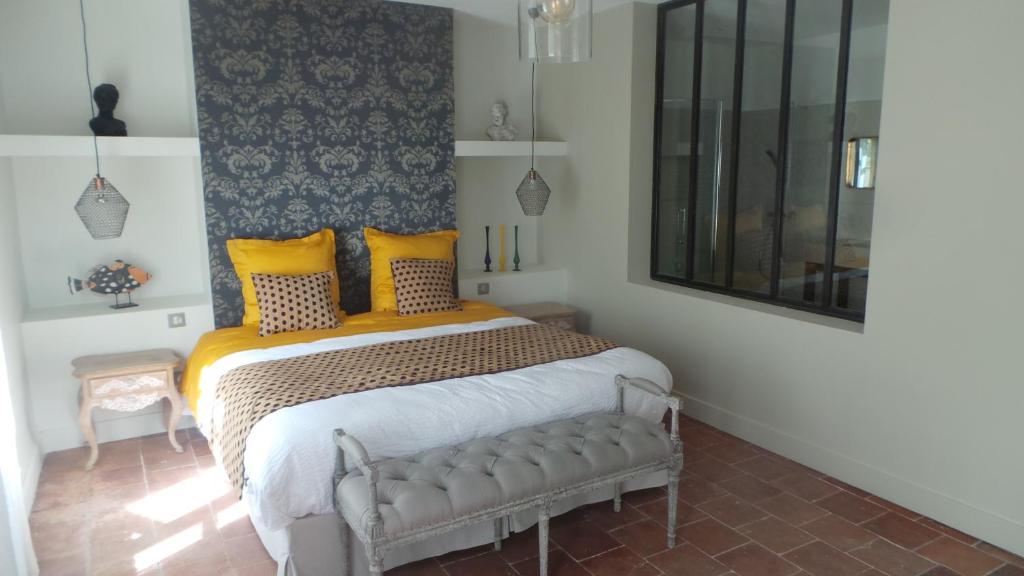 - une chambre avec un grand lit et des oreillers jaunes dans l'établissement LA COUR CARREE, à Carcassonne