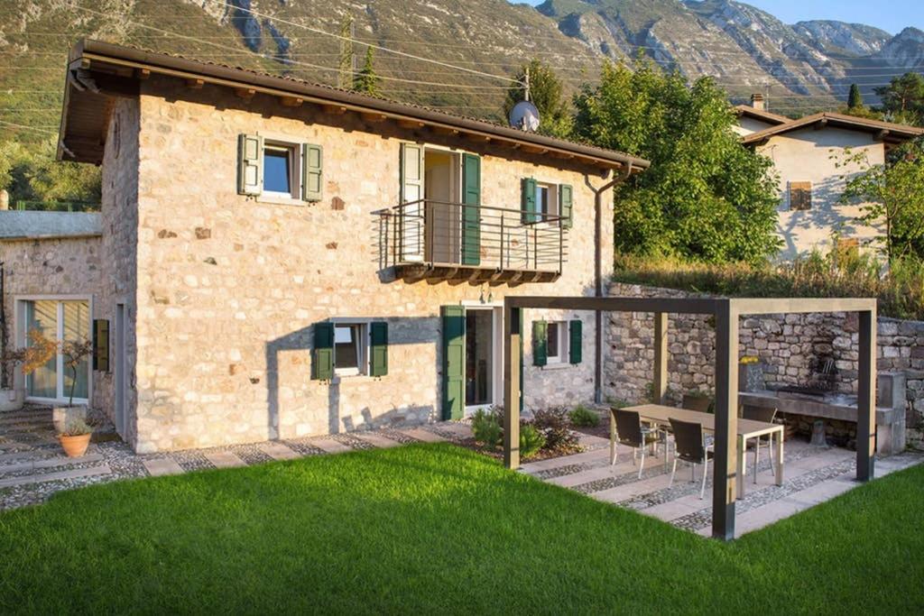 a house with a patio and a table in the yard at Villa Siresola in Malcesine