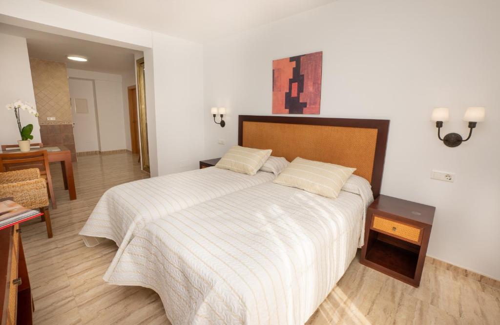 a bedroom with a large bed with a wooden headboard at Apartamentos Jimmy in Nerja