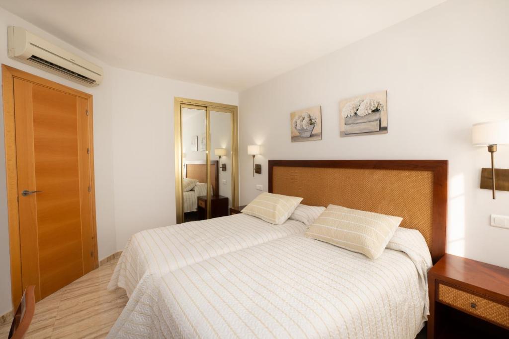 a bedroom with a bed with two pillows on it at Apartamentos Jimmy in Nerja