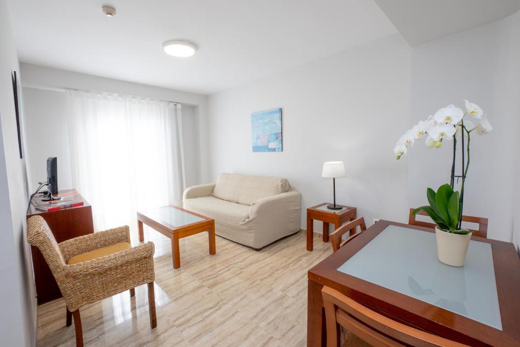 sala de estar con sofá y mesa en Apartamentos Jimmy en Nerja