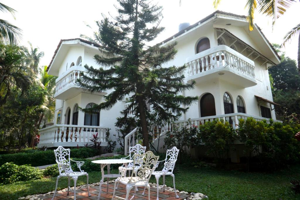 a white house with a table and chairs in front of it at Colonia Santa Maria, A Club M Associate in Baga