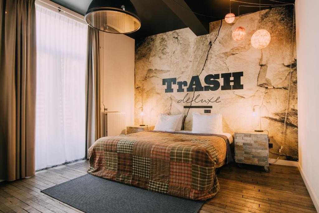 a bedroom with a bed and a stone wall at Hotel Trash Deluxe in Maastricht