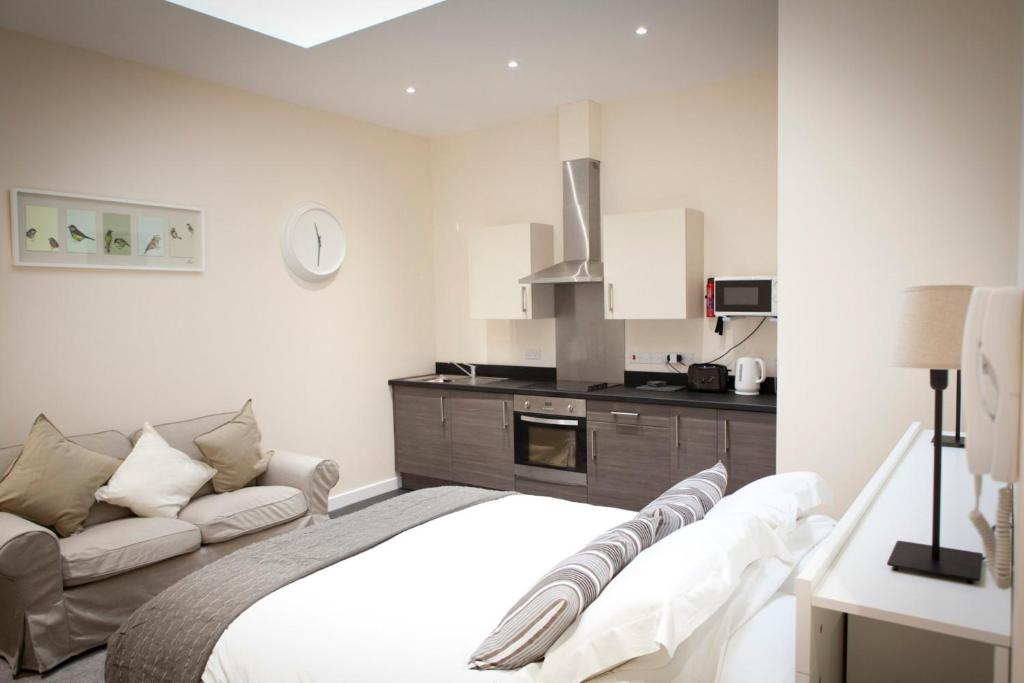um quarto com uma cama e um sofá em Toothbrush Apartments - Ipswich Central East em Ipswich