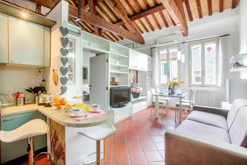 una cucina e un soggiorno con divano e tavolo di Duplex Apartment in centro con posto auto privato a Ferrara