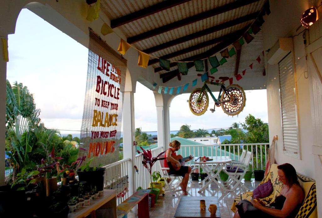 un grupo de personas sentadas en un porche en Happy hippies House en Sainte-Rose