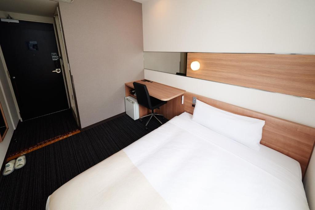Postel nebo postele na pokoji v ubytování Super Hotel Namba Nipponbashi