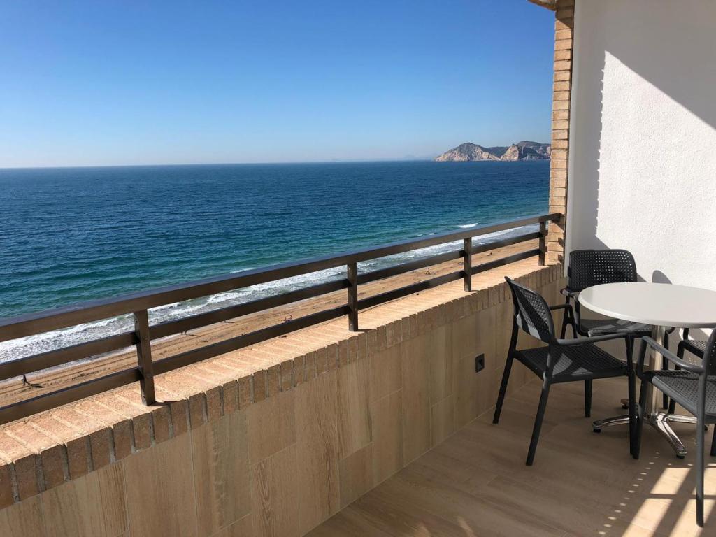 a balcony with a table and chairs and the ocean at Les Dunes Comodoro in Benidorm