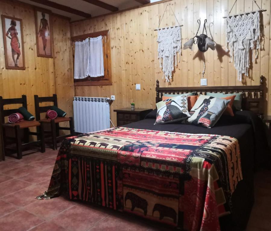 1 dormitorio con 1 cama en una habitación con paredes de madera en Casa Conesa II, en Tronchón