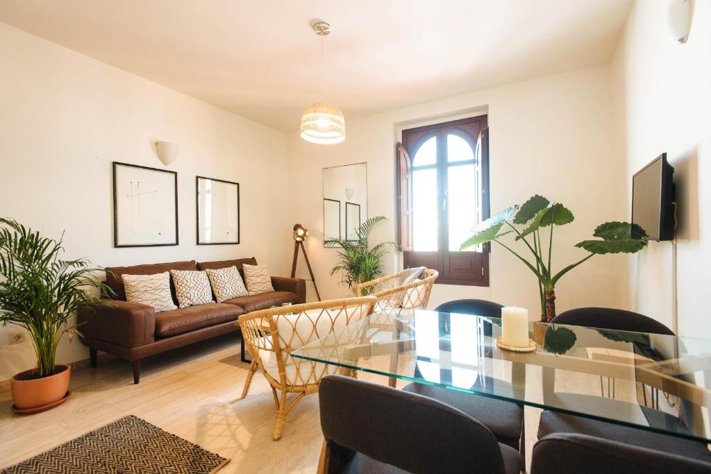 a living room with a glass table and a couch at The Old Print House - Space Maison Apartments in Seville