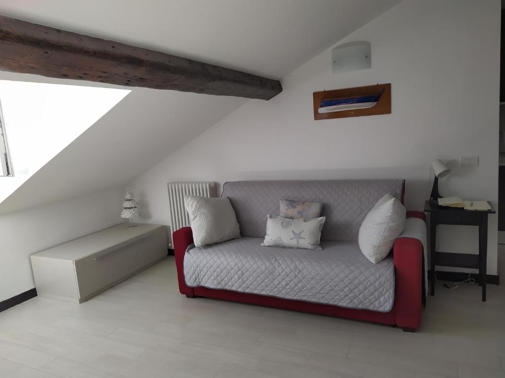a couch with two pillows on it in a room at La mansarda sul Porto in Camogli