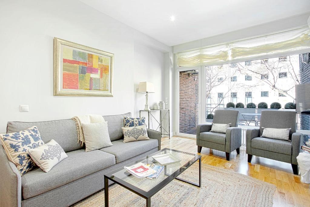 a living room with a couch and two chairs at Genteel Home Retiro in Madrid