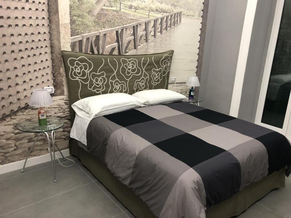 1 cama con manta blanca y negra y 2 mesas en SUNSET BED AND BREAKFAST, en Nápoles