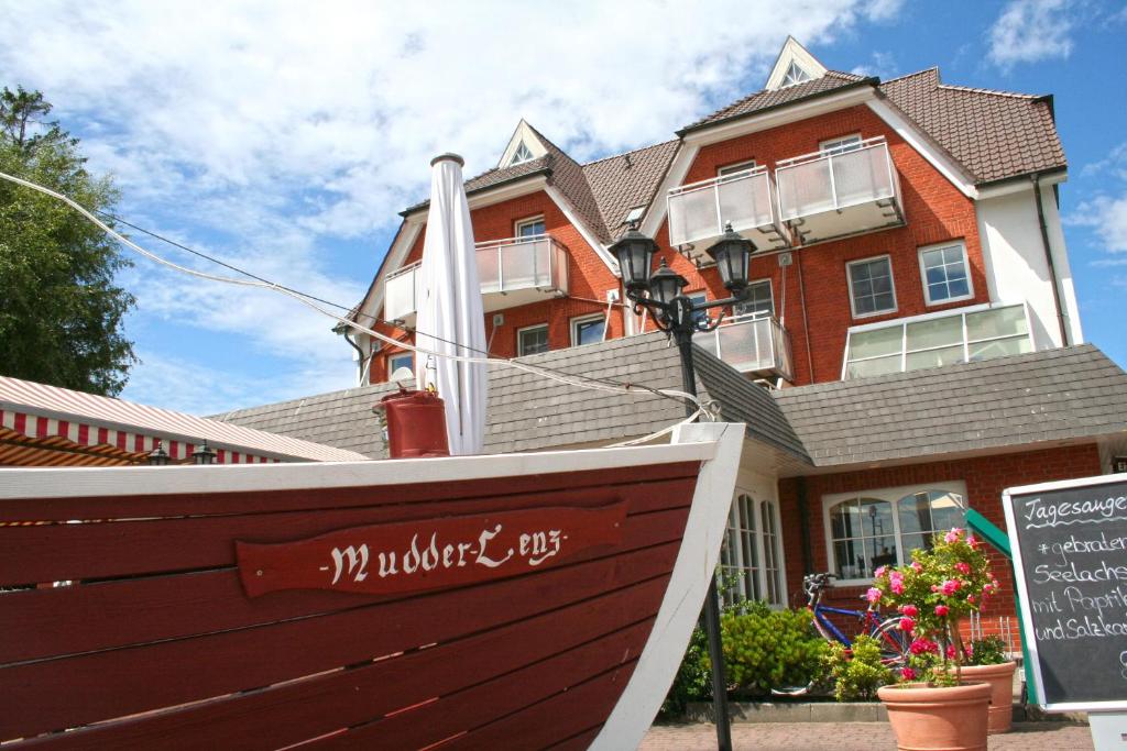 uma casa grande com um barco em frente em Hotel Boddenhus Garni em Zingst