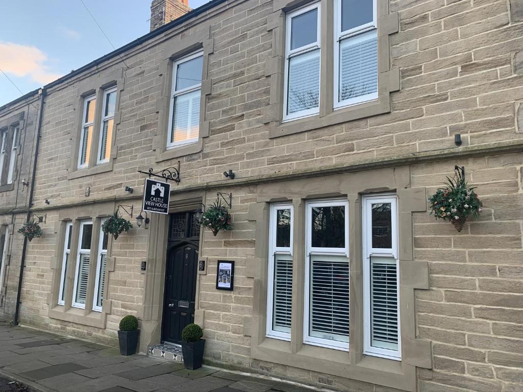 um edifício de tijolos com janelas brancas e uma porta em Castle View Bed and Breakfast em Morpeth