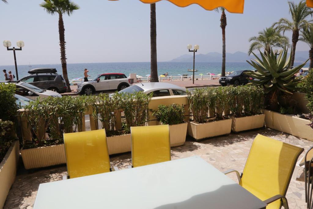 a table and chairs with a view of the beach at Plage du Midi in Cannes