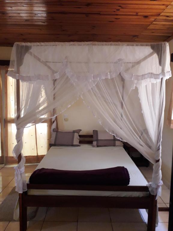 Cette chambre comprend un lit à baldaquin. dans l'établissement LA MARINA 5, à Ambodifotatra
