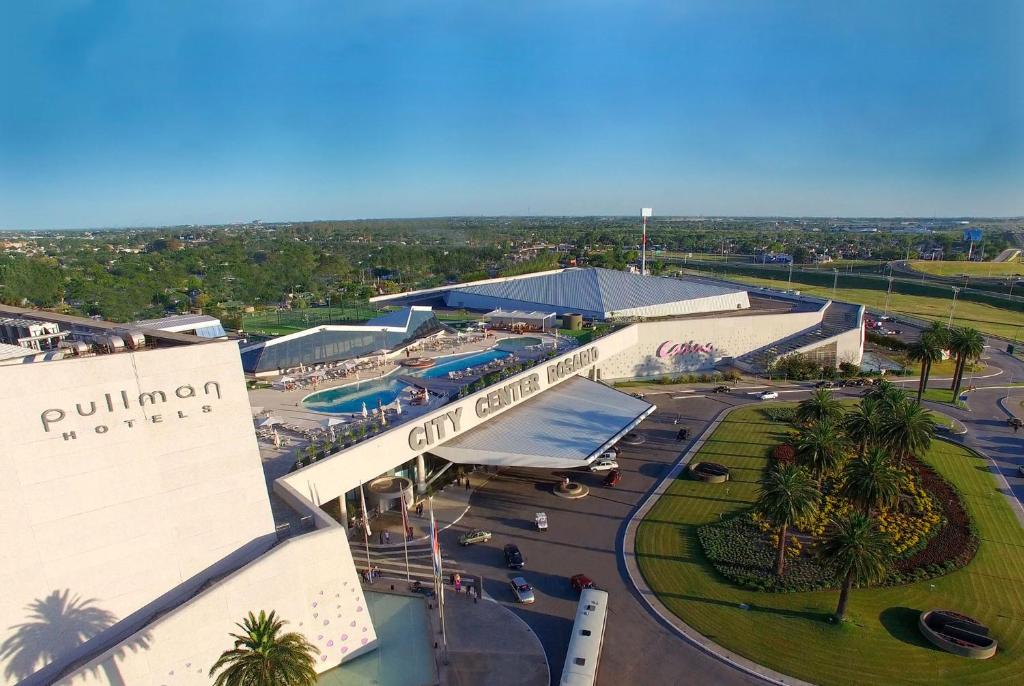uma vista superior de um resort com um parque de estacionamento em Hotel Casino Pullman City Center Rosario em Rosário