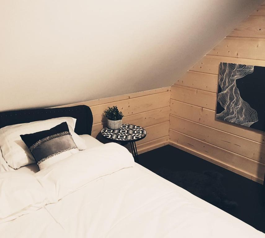 a bedroom with a white bed and a potted plant at Koniakowo - dom Hunter in Koniaków