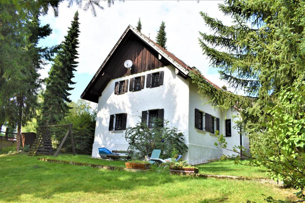 una casa blanca con techo negro en Ferienhaus Marschollek, en Bischofsmais