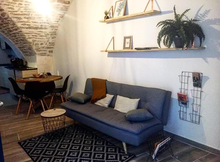 a living room with a blue couch and a table at STUDIO TOUT ÉQUIPÉ in Marguerittes