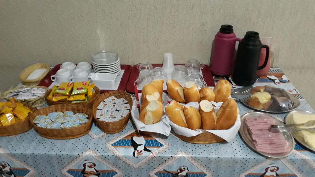 a table with baskets of bread and other food on it at Top Mix Hotel in São Bernardo do Campo