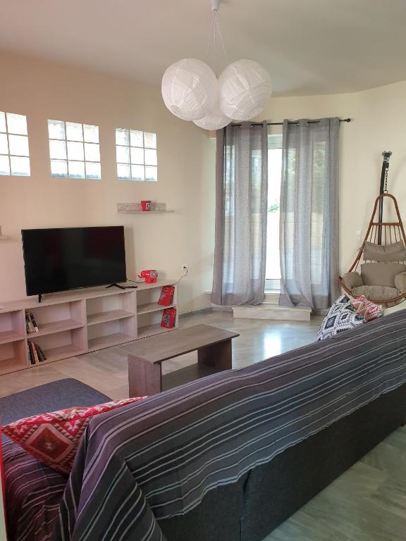 a living room with a flat screen tv and a couch at Maria's Sharing Apartment in Heraklio